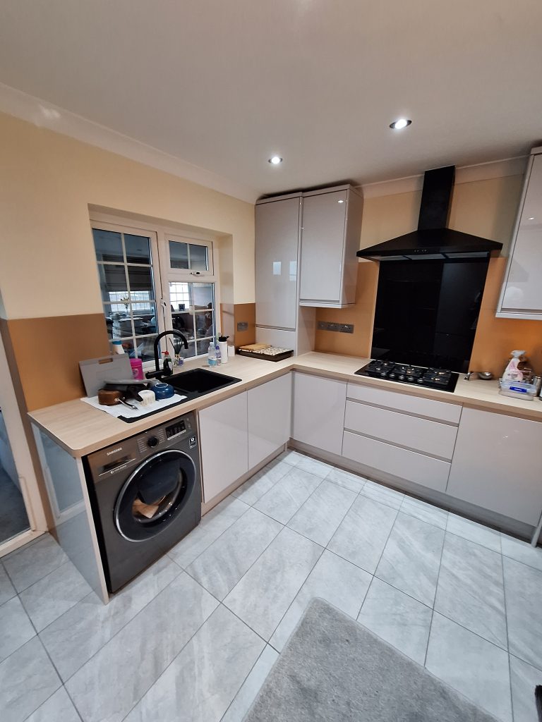 Gloss kitchen with black sink and wood-effect worktops