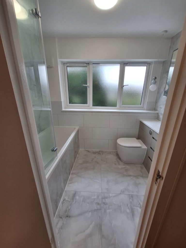 Bathroom with bath, grey vanity and marble-effect floor
