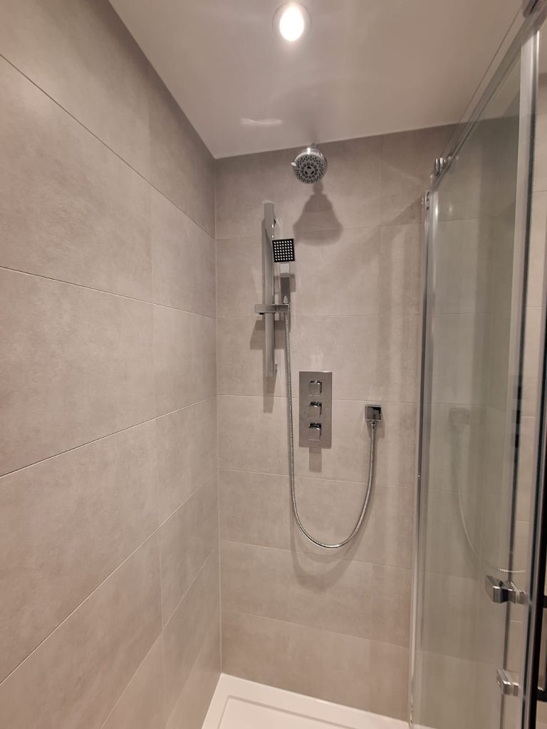 Chrome shower fittings against neutral wall tiles
